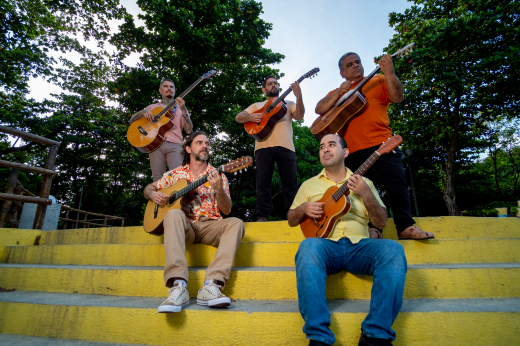 Imagem: homens sentados tocando violão