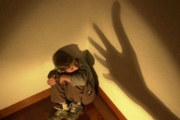 Imagem: Criança acuada na parede, vítima de maus tratos