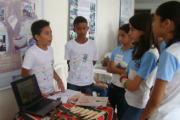 Imagem: Crianças acompanhando apresentação de trabalho em feira de ciências e cultural