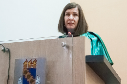 Imagem: Foto da Profª Elisabeth falando no púlpito da cerimônia