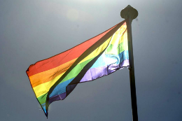 Imagem: Bandeira LGBT num mastro ao vento