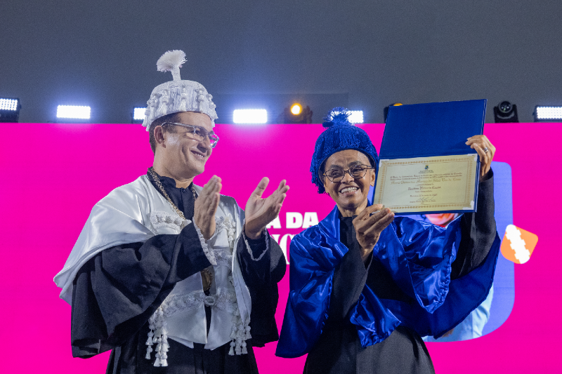 Imagem: Foto do reitor Custódio Almeida à esquerda, com veste talar, e da deputada Marina Silva à esquerda, segurando o título de Doutora Honoris causa pela UFC