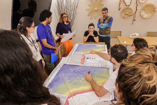 Imagem: pesquisadores ao redor de mesa observam mapa