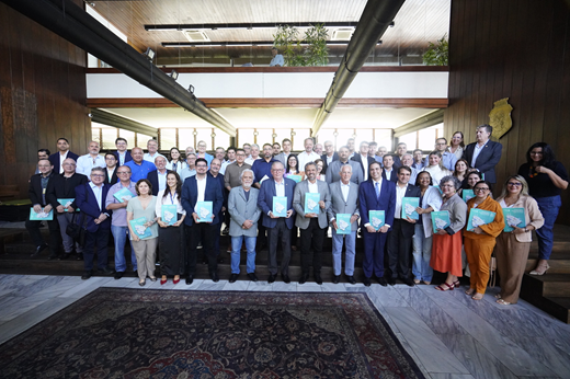 Imagem: O presidente da FIEC, Ricardo Cavalcante, e o governador Elmano de Freitas (ao centro) posam no Palácio da Abolição com acadêmicos, gestores públicos, parlamentares e empresários. Todos seguram o livro "Construindo o hub de hidrogênio verde do Ceará". (Foto: ASCOM FIEC/Divulgação)