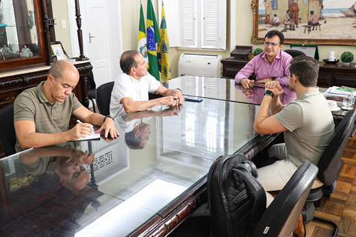 Imagem: Participantes da reunião sentados à mesa no Gabinete da Reitoria.