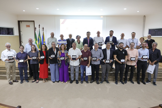 Os pesquisadores homenageados posam no auditório do evento com suas placas comemorativas