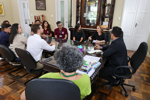 Imagem: Participantes da reunião sentados à mesa no Gabinete da Reitoria.