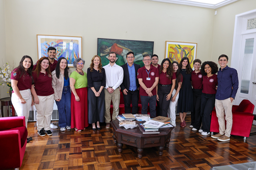 Imagem: De pé, no Gabinete da Reitoria, estudantes de Medicina da UFC ladeiam a vice-reitora Diana Azevedo, a prefeita de Crateús Janaína Farias, o reitor Custódio Almeida e os integrantes de comitiva da USP; pauta foi levar Expedição Cirúrgica a Crateús.