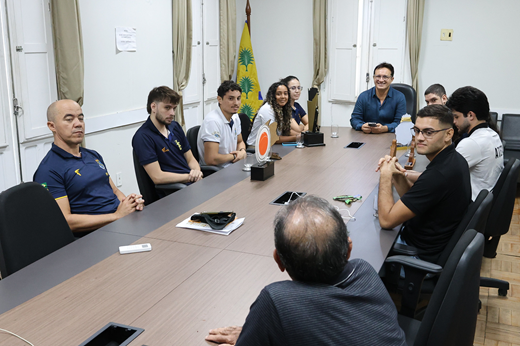 Em um primeiro momento, foram discutidas demandas e infraestrutura desportiva na UFC. (Foto: Viktor Braga/ UFC Informa) Imagem: Reitor, gestores da Secretaria de Esportes e estudantes-atletas sentados à mesa durante a reunião