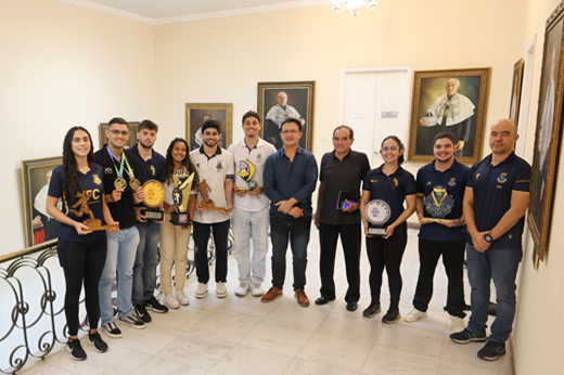 Atletas individuais e integrantes das seleções esportivas da UFC compartilharam com a gestão superior os principais resultados do desporto universitário em 2025. (Foto: Viktor Braga/UFC Informa) Imagem: De pé, na entrada do Gabinete da Reitoria, oito atletas (três jovens do sexo feminino e cinco do sexo masculino) posam junto com o reitor Custódio Almeida, o secretário Antônio Lima e o secretário-adjunto Wildner Lins