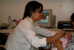 Imagem: Adrianna Teixeira, fonoaudióloga do Nutep, faz o teste da orelhinha no bebê