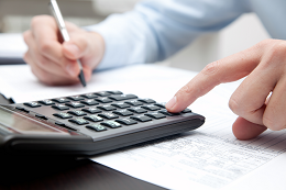 Imagem: Caneta e calculadora sobre formulários de imposto de renda