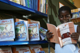 Imagem: Criança de escola quilombola folheia livro em biblioteca