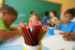 Imagem: Crianças em uma sala desenhando com lápis de cor