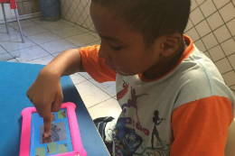 Imagem: foto de um menino usando o aplicativo num tablet