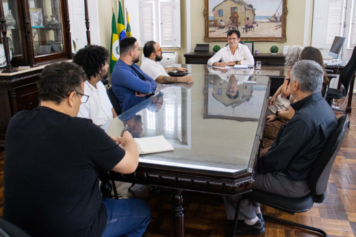 Imagem: Foto da reunião com o reitor Custódio Almeida sentado na ponta da mesa