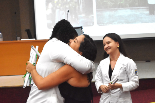 Alunas se abraçando durante a entrega do certificado da residência