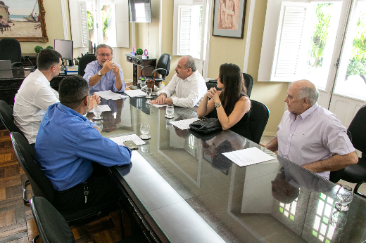 Imagem: pessoas em volta de uma mesa em reunião