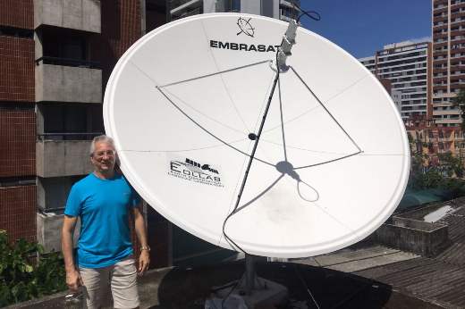 Imagem: Homem de blusa azul ao lado de uma antena