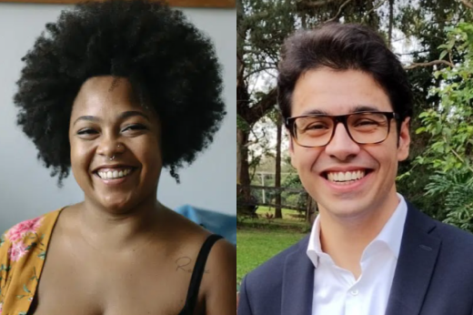 Imagem: Duas pessoas sorridentes lado a lado. À esquerda, Stéfane Souto, uma mulher negra com cabelo afro volumoso, vestindo uma blusa com estampas florais de tons quentes. Ela está com uma expressão de alegria, exibindo um sorriso amplo. À direita, André Frota, um homem branco de cabelos escuros curtos e óculos de armação preta, vestindo um terno escuro com uma camisa social branca por baixo. Ele também está sorrindo, com um fundo de árvores ao ar livre ao seu redor