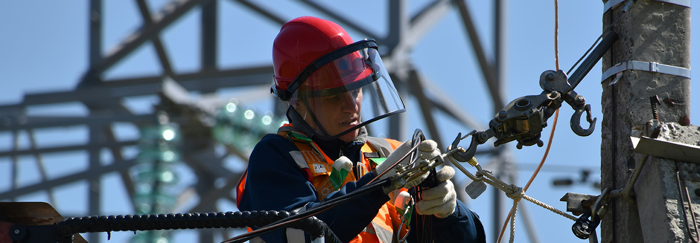 Profissional com equipamentos de proteção individual faz reparo em rede elétrica